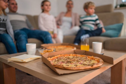 pizza at wooden table in middle of living room - junk food stock pictures, royalty-free photos & images