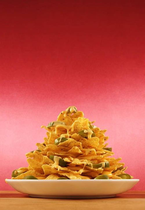 plate piled very high with nachos - junk food stock pictures, royalty-free photos & images