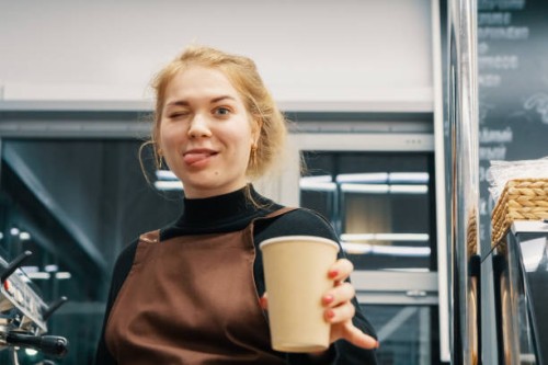 playful barista holding coffee cup - junk food stock pictures, royalty-free photos & images