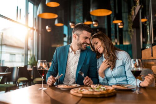 playful couple eating pizza together in a restaurant. - food stock pictures, royalty-free photos & images