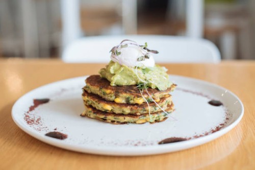 poached egg, smashed avocado and corn and zucchini fritters - food stock pictures, royalty-free photos & images