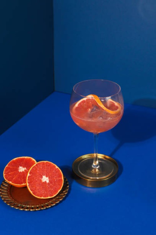pop art style gin cocktail with grapefruit citrus fruit in blue background - fashion stock pictures, royalty-free photos & images