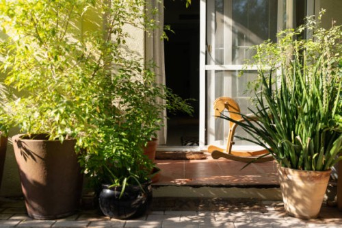 porch with potted plants and wooden rocking horse in a garden - garden decoration stock pictures, royalty-free photos & images