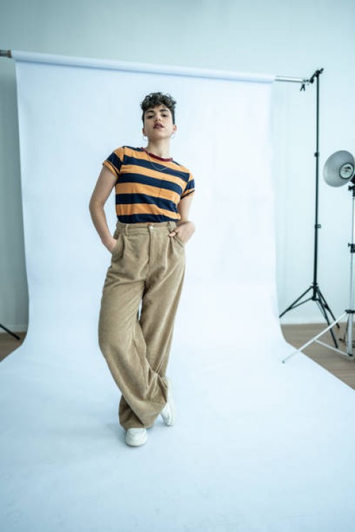 porträt einer jungen modellfrau mit händen in taschen im atelier - fashion stock-fotos und bilder