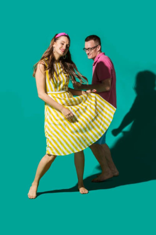 portrait carefree couple dancing against turquoise background - fashion stock pictures, royalty-free photos & images