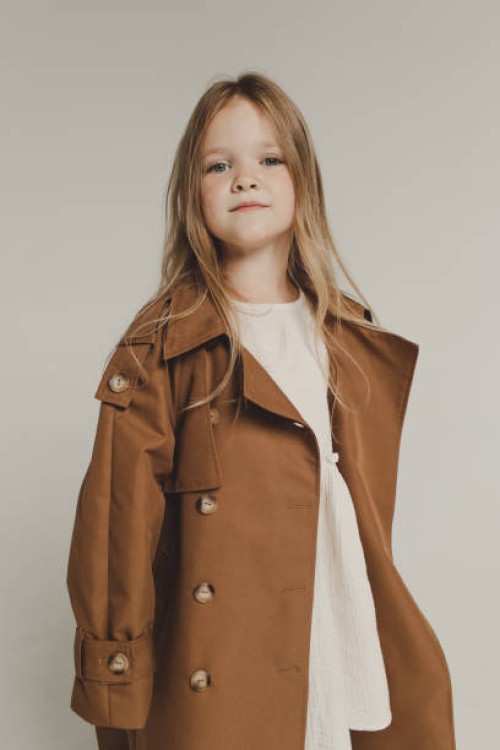 portrait of a beautiful girl with long blonde hair in an autumn trench coat on a white background - fashion stock pictures, royalty-free photos & images
