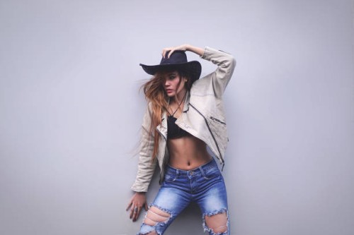 portrait of a beautiful young woman wearing cow girl hat posing on the wall - fashion stock pictures, royalty-free photos & images