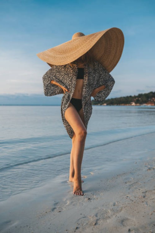 portrait of a blonde woman with an oversized straw hat on the beach - fashion stock pictures, royalty-free photos & images
