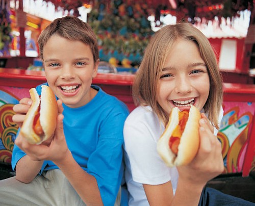 portrait of a brother and sister holding hot dogs - food stock pictures, royalty-free photos & images