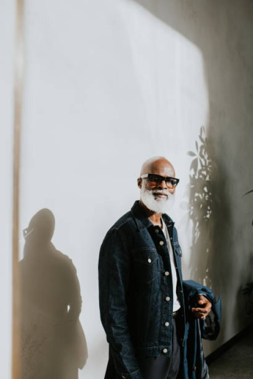 portrait of a confident older gentleman looking directly at the camera against a plain background - fashion stock pictures, royalty-free photos & images