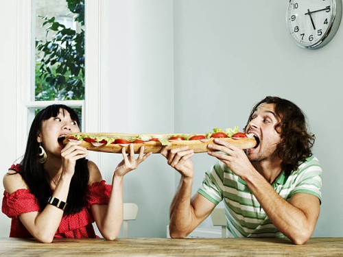 portrait of a couple sharing a baguette - junk food stock pictures, royalty-free photos & images