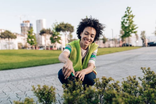 portrait of a female city gardener taking care of the park plants - garden decoration stock pictures, royalty-free photos & images