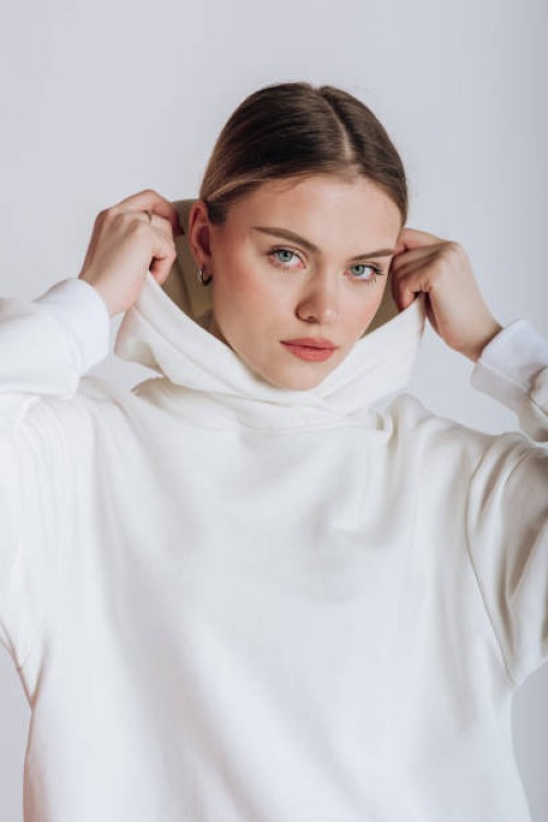 portrait of a female model in a hoodie on a white background - fashion stock pictures, royalty-free photos & images