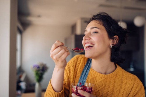 portrait of a happy girl enjoying fresh pomegranate at home - food stock pictures, royalty-free photos & images