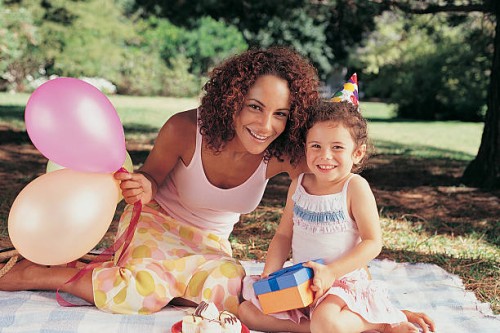 portrait of a mother and daughter sitting in the garden at a birthday party - garden decoration stock pictures, royalty-free photos & images