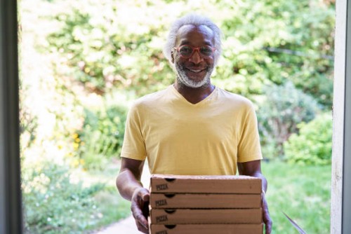 portrait of a senior deliveryman delivering pizza - junk food stock pictures, royalty-free photos & images