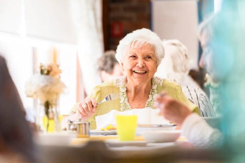 portrait of a smiling senior woman having lunch with friends - food stock pictures, royalty-free photos & images