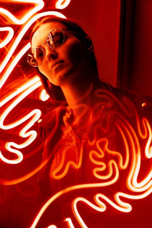 portrait of a woman in glasses against red neon sign - fashion stock pictures, royalty-free photos & images