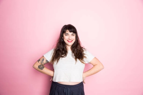 portrait of a woman with tattoos and red lipstick against a pink background - fashion stock pictures, royalty-free photos & images
