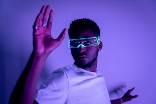 portrait of a young african american man in futuristic fashion illuminated glasses with purple neon light. concept of the future, modern technologies, technological progress, cyclops glasses - fashion stock pictures, royalty-