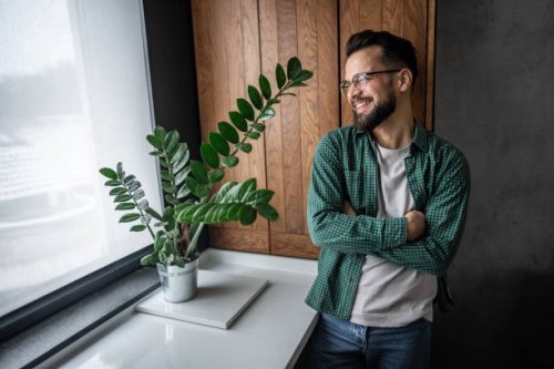 portrait of a young handsome man with a confident attitude and crossed arms - hairstyle stockfoto's en -beelden