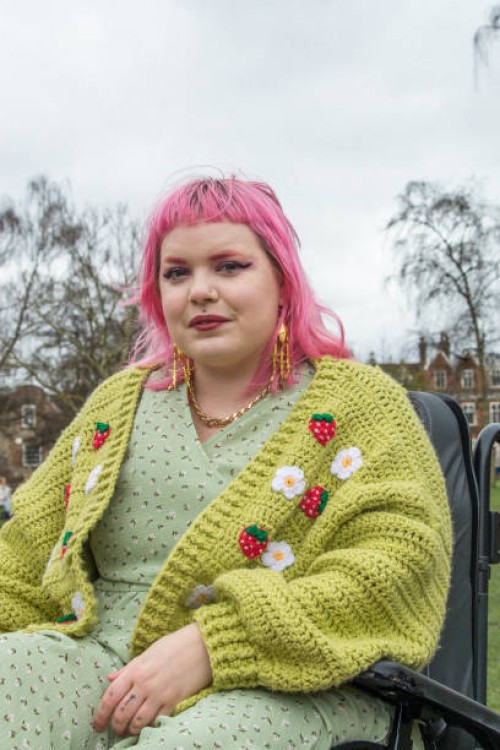 portrait of a young non-binary person with colourful hair sitting in an electric wheelchair - fashion stock pictures, royalty-free photos & images