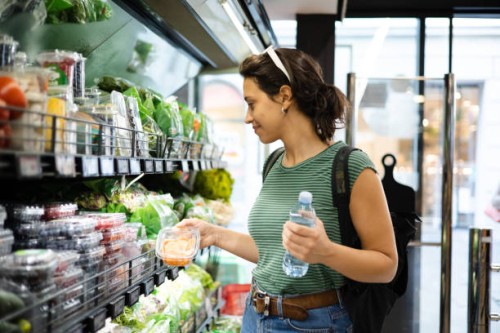 portrait of a young woman buying fresh vegetables at the grocery store - food stock pictures, royalty-free photos & images