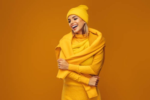 portrait of a young woman wearing yellow sweater and hat - fashion stock pictures, royalty-free photos & images