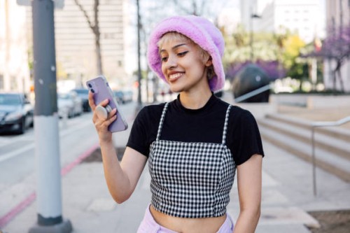 portrait of a young woman with her mobile phone texting and scrolling social media in the streets - fashion stock pictures, royalty-free photos & images