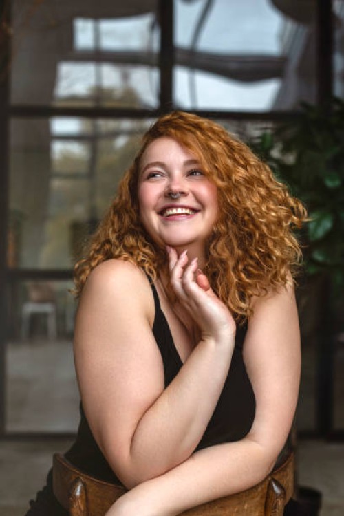 portrait of an attractive and voluptuous young woman posing in background in studio - fashion stock pictures, royalty-free photos & images