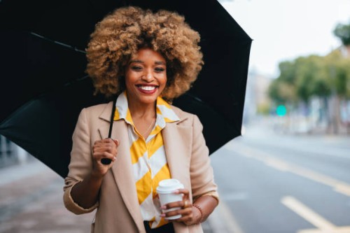 portrait of an elegant african american woman with paper cup standing on the street - junk food stock pictures, royalty-free photos & images