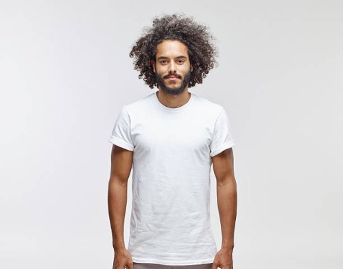 portrait of bearded young man with curly brown hair wearing white t-shirt - hairstyle photos et images de collection
