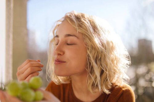 portrait of blond young woman eating green grapes - food stock pictures, royalty-free photos & images