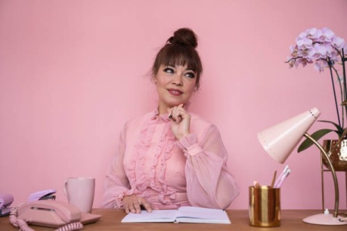 portrait of businesswoman in ruffled blouse sitting at desk - home decoration stock pictures, royalty-free photos & images