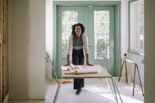 portrait of confident female architect leaning on table at under construction apartment - home decoration stock pictures, royalty-free photos & images