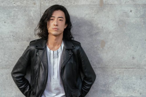 portrait of cool young handsome man wearing leather jacket and leaning against concrete wall - fashion stock pictures, royalty-free photos & images
