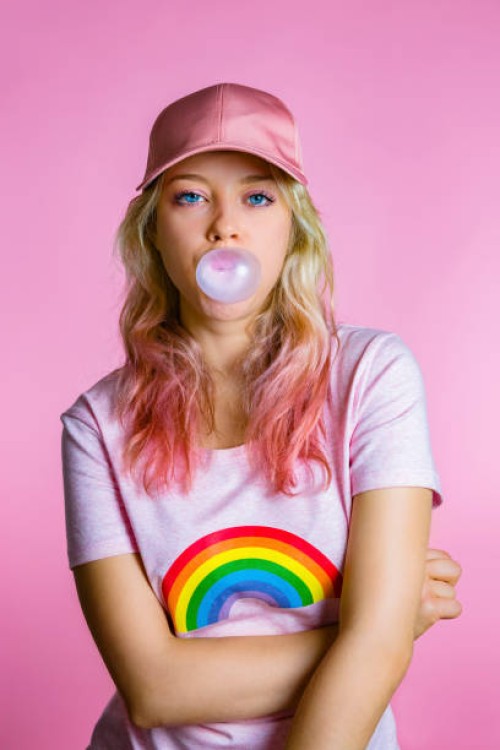 portrait of cool young woman with bubble gum in front of pink background - fashion stock pictures, royalty-free photos & images