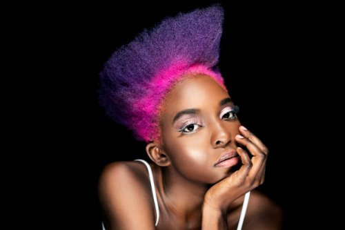 portrait of eccentric young woman with pink and purple dyed hair in front of black background - hairstyle stock pictures, royalty-free photos & images