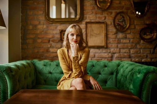 portrait of elegant woman sitting on a couch - fashion stock-fotos und bilder