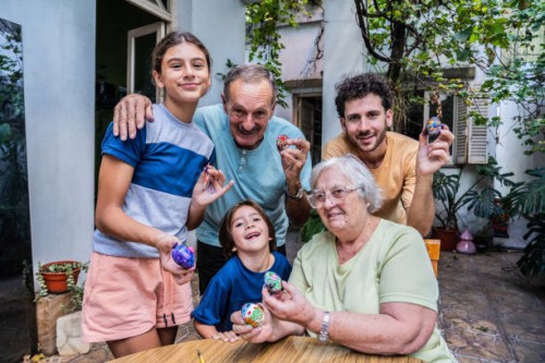 portrait of family decorating easter eggs together at home - garden decoration stock pictures, royalty-free photos & images