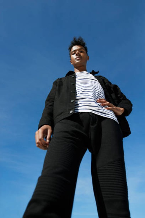 portrait of fashionable man standing against blue sky - fashion stock pictures, royalty-free photos & images