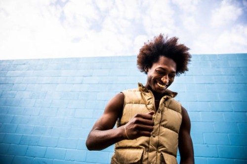 portrait of fashionable young man in front of bright blue wall - fashion stock pictures, royalty-free photos & images