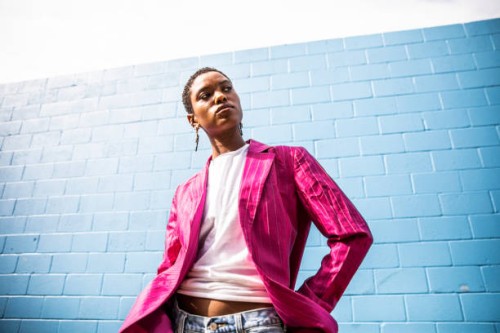 portrait of fashionable young woman in front of bright blue wall - fashion stock pictures, royalty-free photos & images