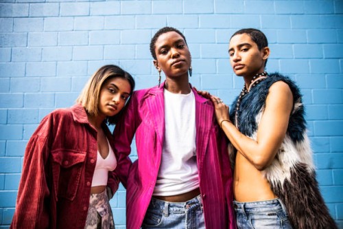 portrait of fashionable young women in front of bright blue wall - fashion stock pictures, royalty-free photos & images