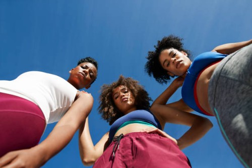 portrait of female athletes in sportswear against blue sky - fashion stock pictures, royalty-free photos & images