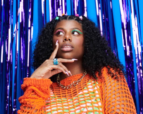 portrait of genz woman standing in front of a blue and purple metallic curtain background. - fashion stock pictures, royalty-free photos & images