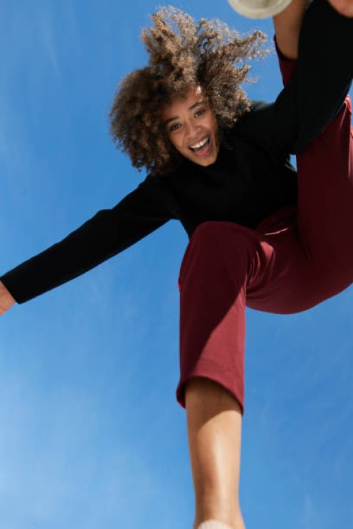 portrait of happy young woman against blue sky - fashion stock pictures, royalty-free photos & images