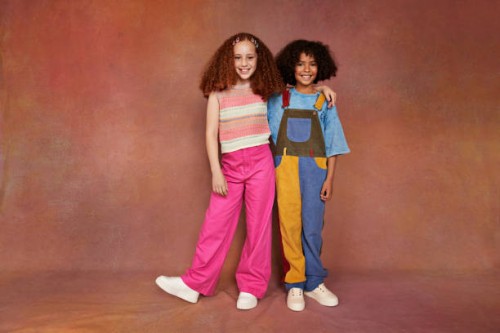 portrait of smiling boy and girl standing with arm around - fashion stock pictures, royalty-free photos & images