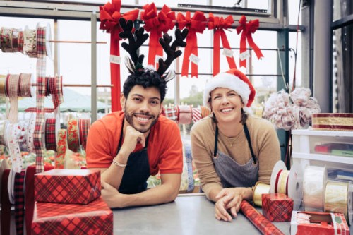 portrait of smiling co-workers in christmas shop - home decoration stockfoto's en -beelden