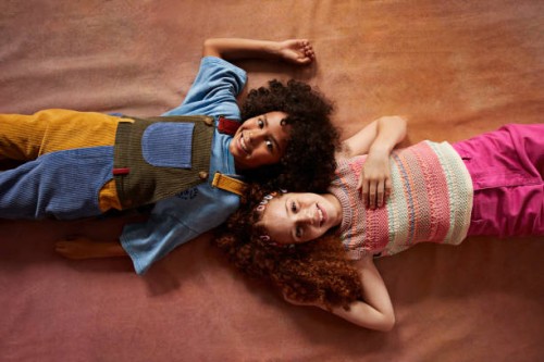portrait of smiling multiracial girls lying together - fashion stock pictures, royalty-free photos & images